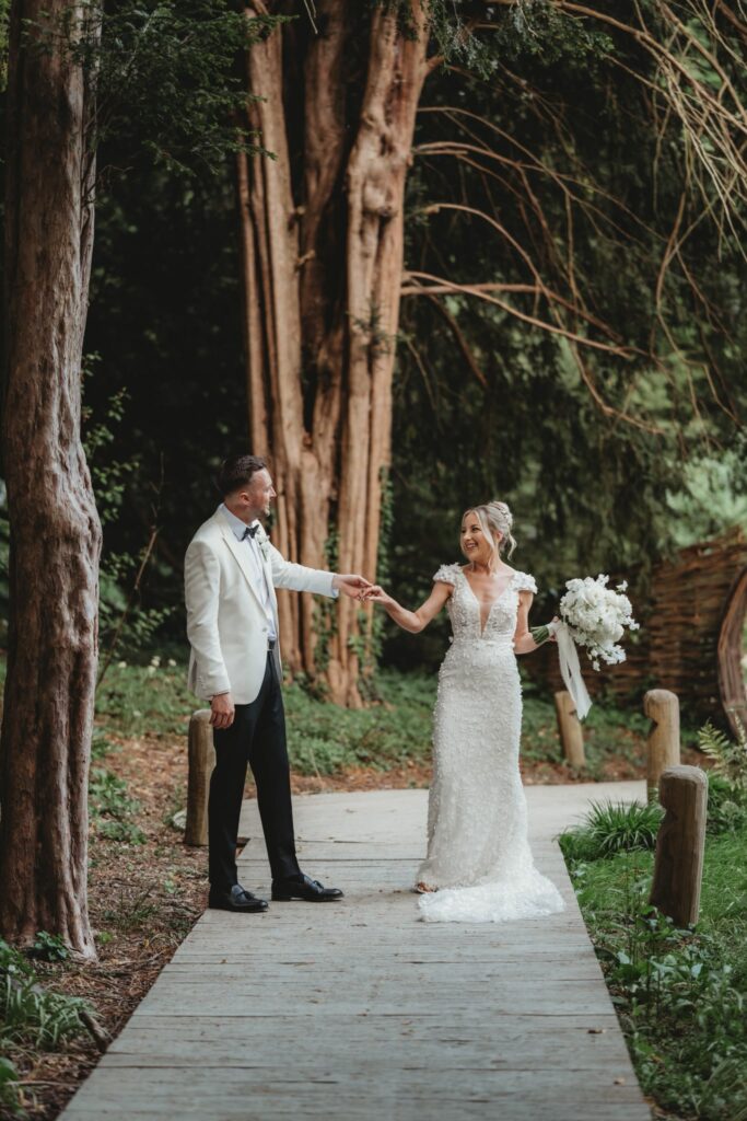 Intricate floral detailing on a Made With Love Darcy wedding dress bride and bride groom walking outside around the venue.