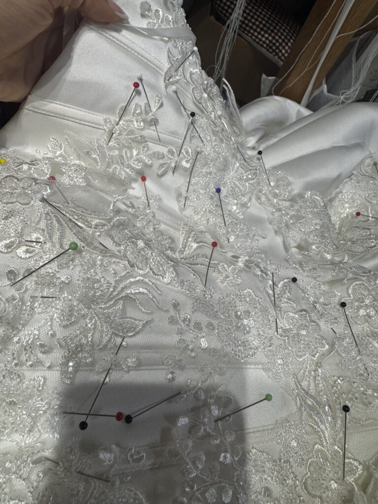 Uxbridge bridal alterations for a completely transformed WED2B Jules wedding dress lace Applique all pinned and hand sewn on bodice waist below waist front and back and train hem.