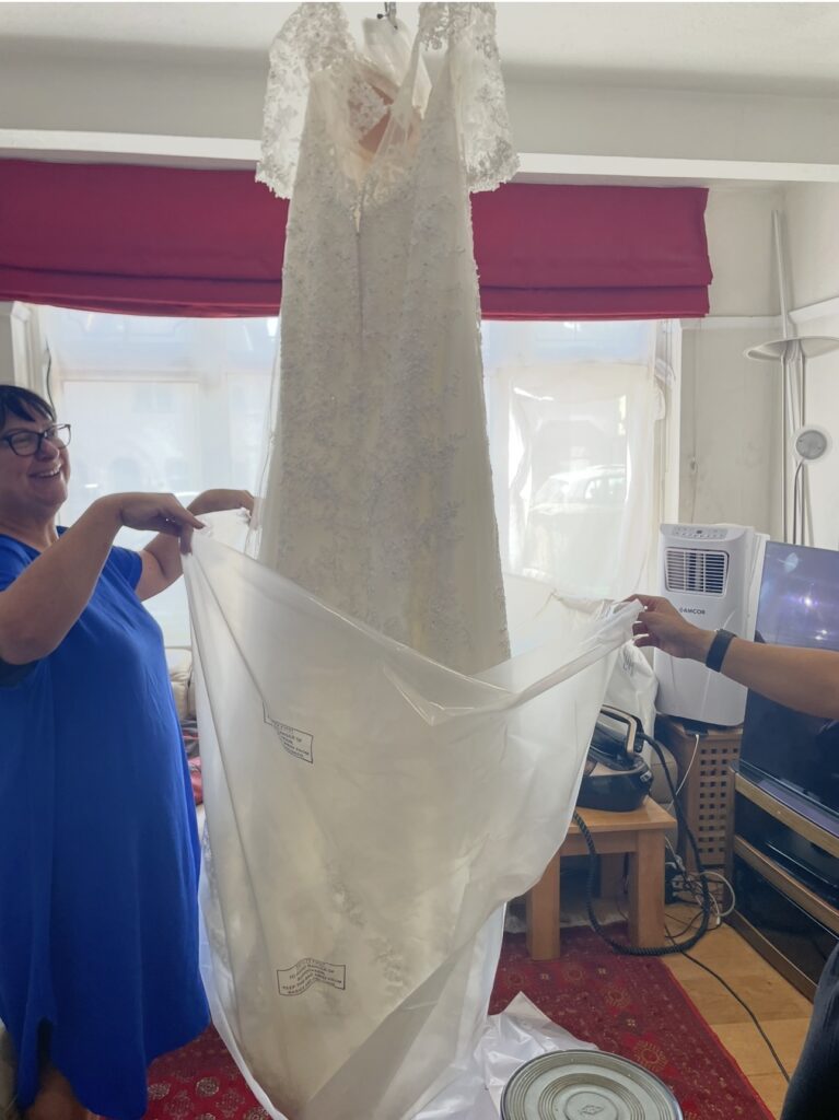 professional comprehensive steam press and packaging service bride helping to bag dress.