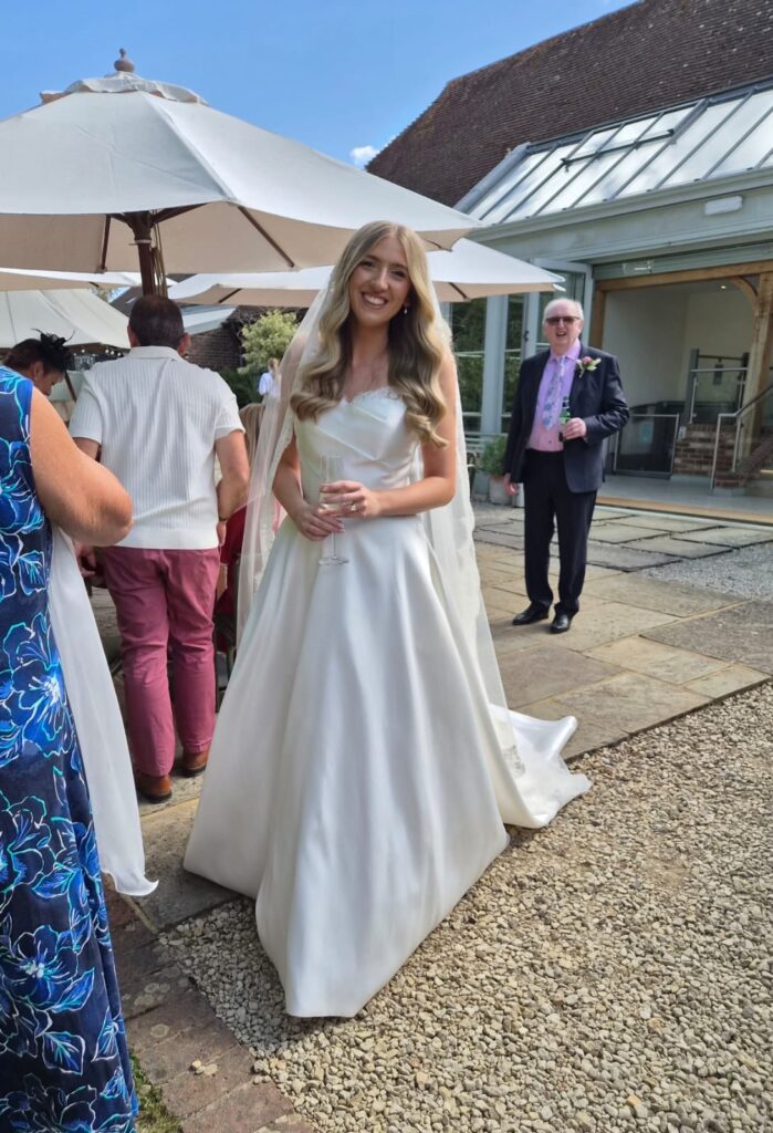 Bride wearing her altered Allure Carmena wedding dress after Leatherhead wedding dress alterations ceremony celebrations.