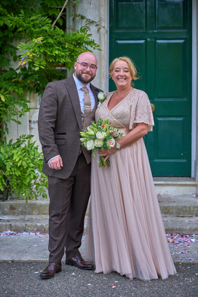Carshalton bride Jo wearing her altered beaded blush wedding dress with her son who also had his suit altered at Tailoring & Alternations Sutton.