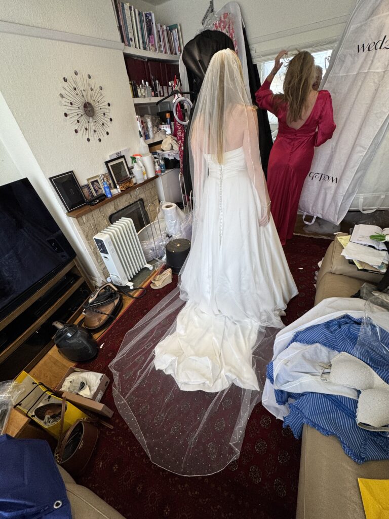 back view of brides dress and mum in their dresses on the final fitting day at my Greater London Studio.