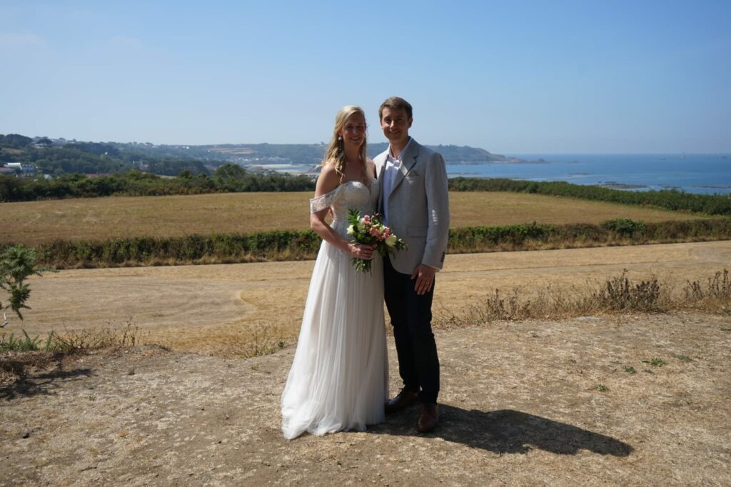 Bride wearing her altered Heidi Hudson Hali wedding dress beside the groom at a lakeside wedding day near seaside