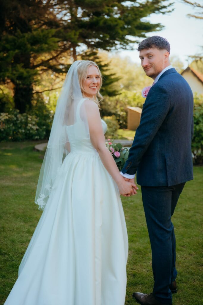 Bride wearing House of CB wedding dress after bust and waist alterations taken in full size down.