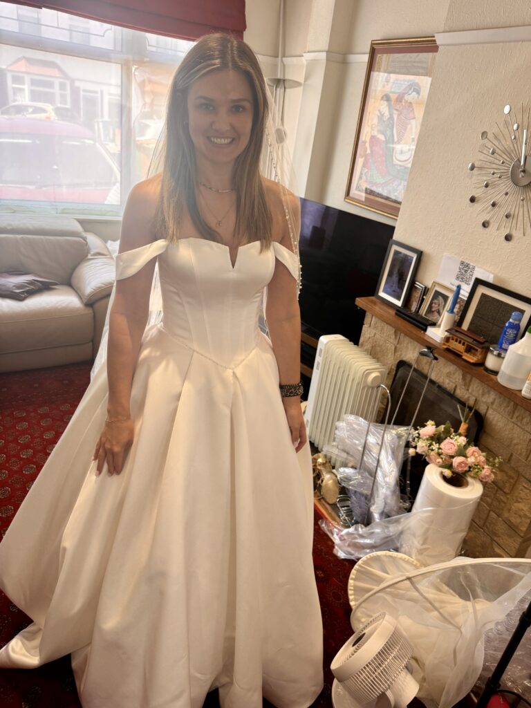 Finished bridal alterations for Molesey bride in structured satin wedding dress front view.