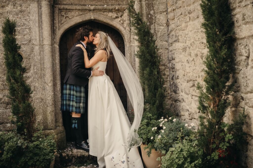 Bride and groom outside Pengersick Castle following their intimate Cornish wedding ceremony