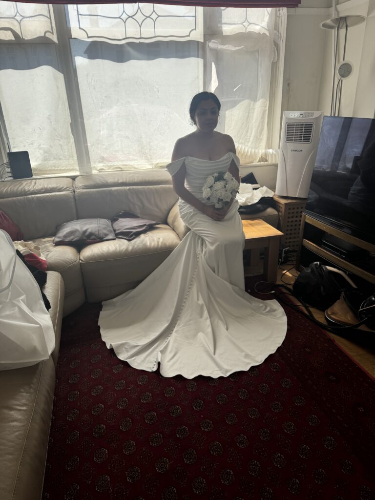 West Norwood bride wearing a Blue Willow by Anne Barge wedding gown after couture bridal alterations sitting down at final fitting.