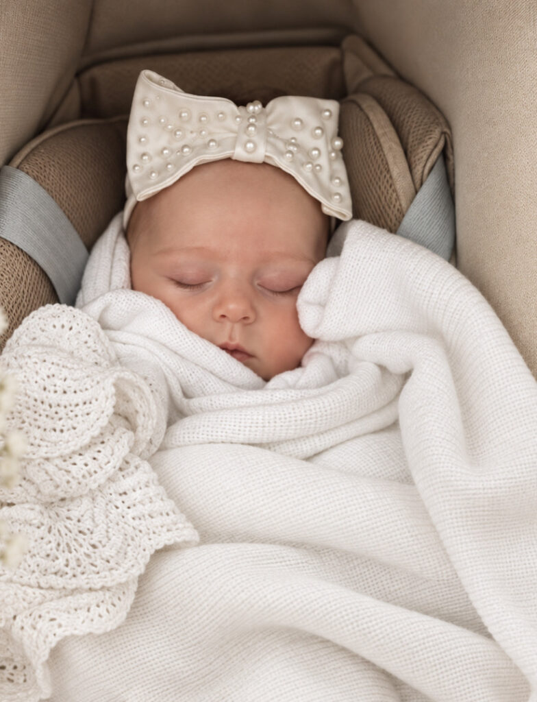 Baby Maeve wearing the pearl bow made from bride’s hem remnants.