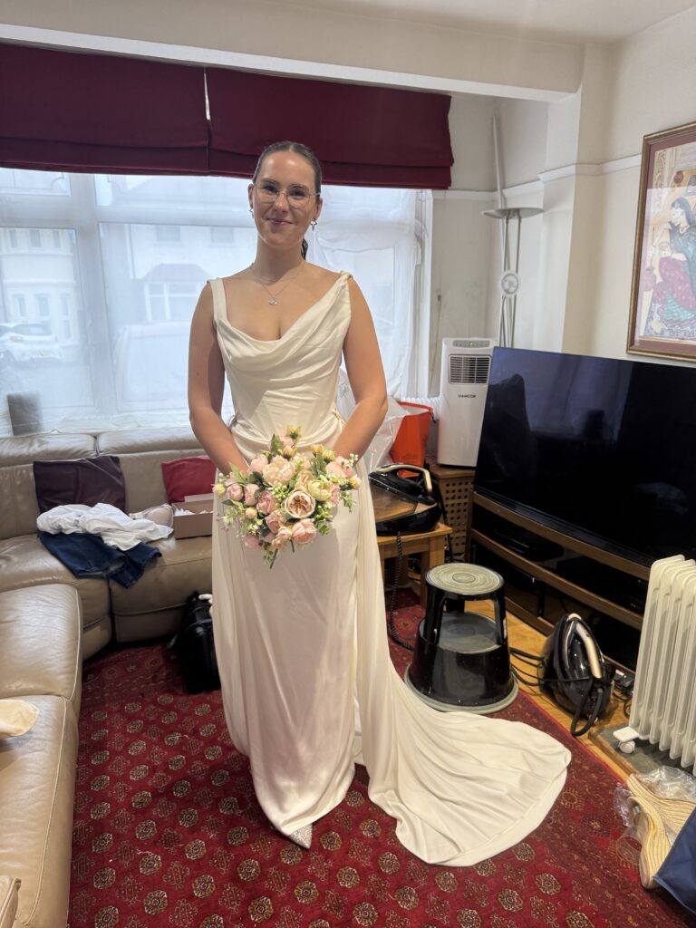 Bride happily holding a bouquet at the final fitting at my Studio in Greater London.