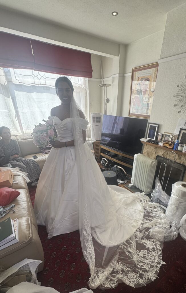 Bride looking happy wearing her WED2B Sofia Cruz Jade gown during a fitting in Sutton for Hayes and Pinner bridal alterations.