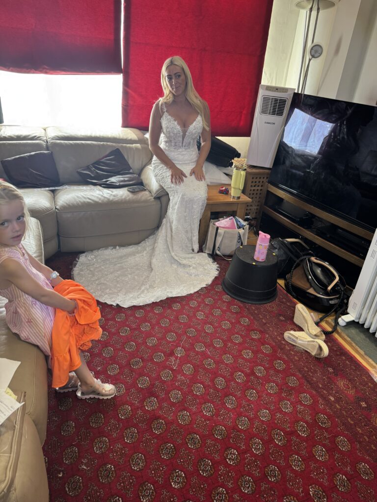 Hackbridge bride in altered Danielle Couture lace wedding dress at my Studio trying to sit in dress.