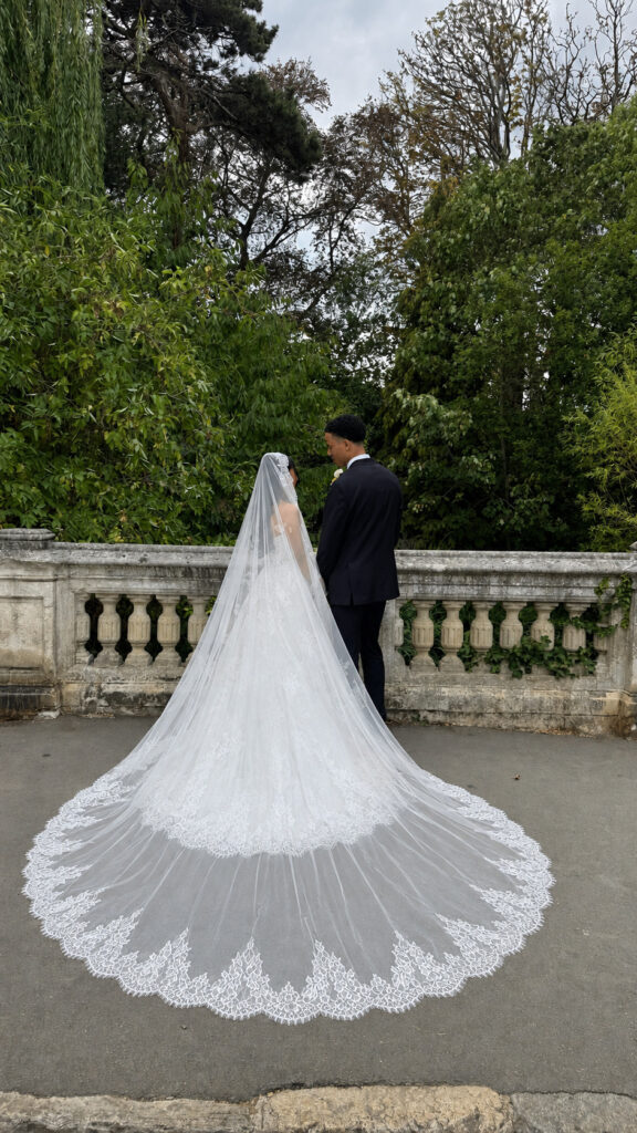 Bride and groom showing the full lace train and veil of the altered Mercia gown