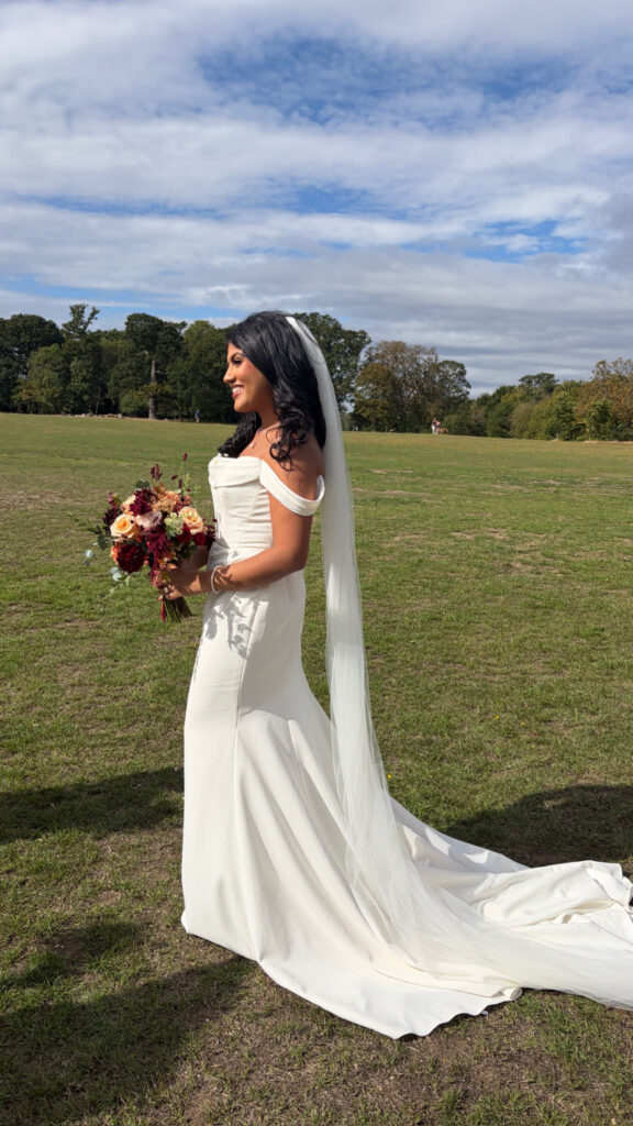 side view of the bride on wedding dat shows dress with Cathedral veil.
