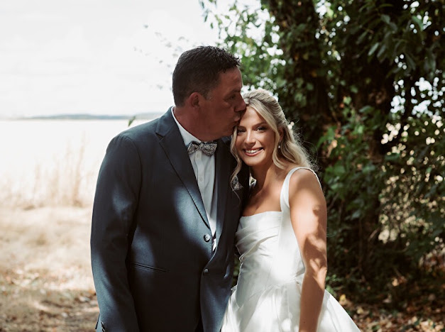 Bride in her Milla Nova Ermana gown receiving a kiss on the forehead