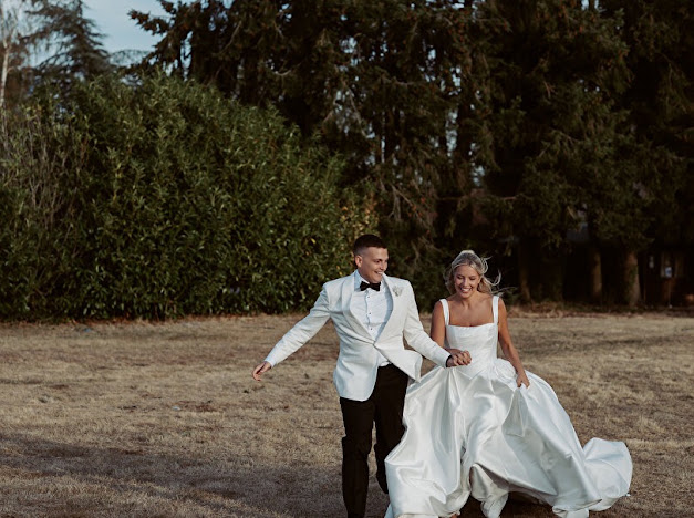 Bride lifting her beautifully altered full Mikado skirt of her Milla Nova Ermana Ballgown while walking hand in hand with the groom