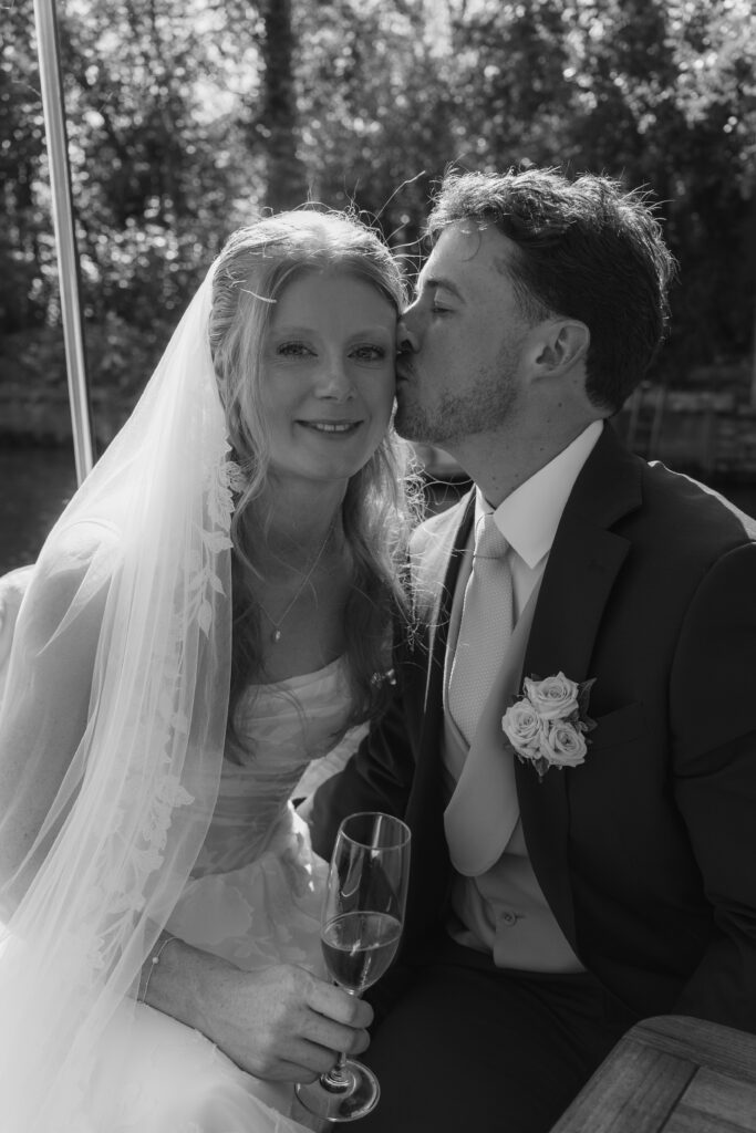 portrait of bride and groom black and white kissing.