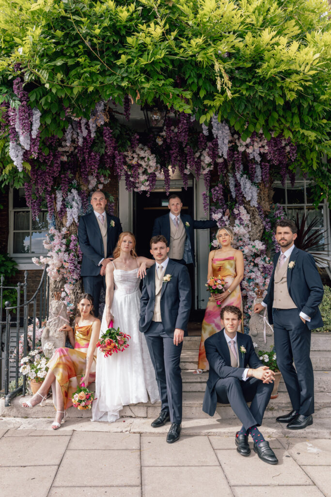 Worcester Park Bride in Stella York 8055 with the groom and wedding party beneath cascading purple flowers, bridal dress altered to perfection.