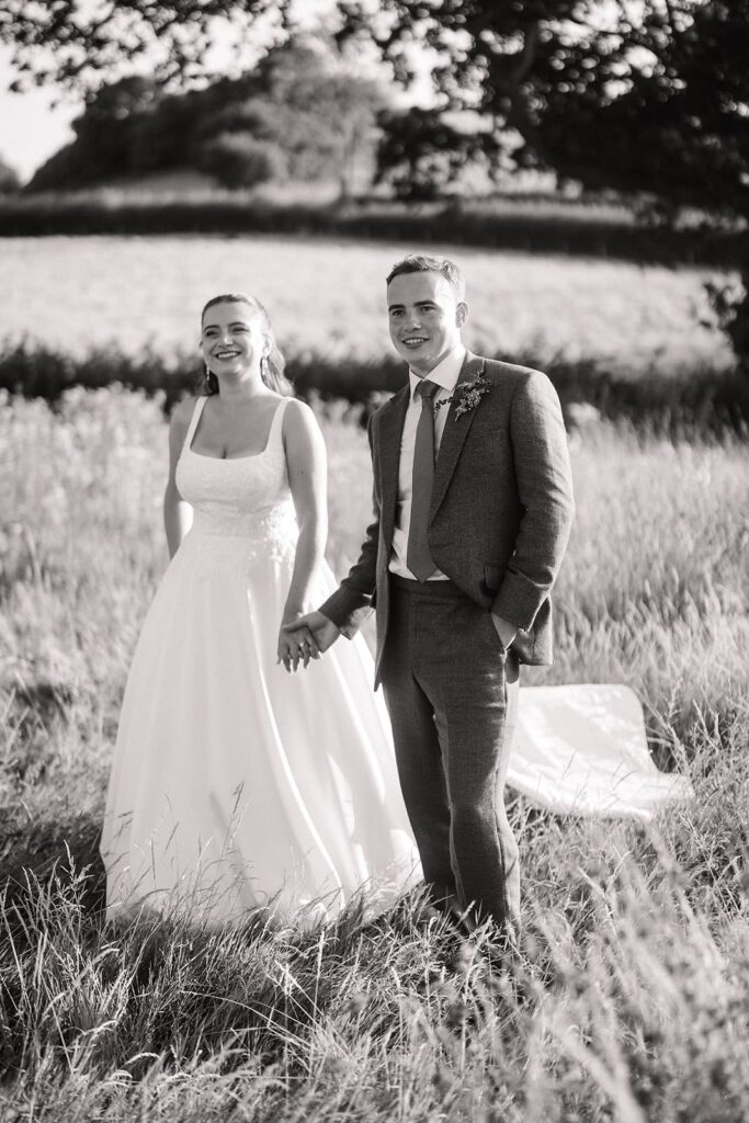 Bride wearing her altered Stella York wedding dress on her wedding day walking with groom.