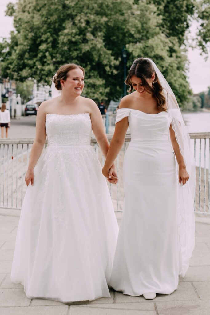 Two brides walking together in their professionally altered WED2B wedding dresses