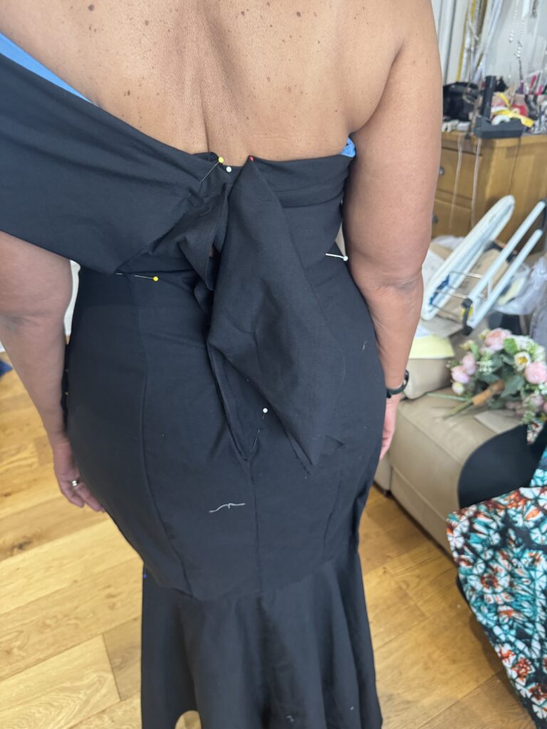 Pinned back of the black calico toile showing neckline and bodice adjustments.