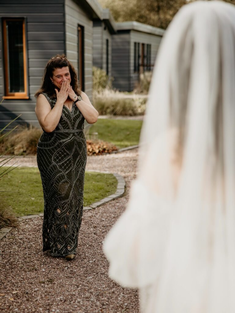 Mother of the bride reacting emotionally during her daughter's wedding-day first look