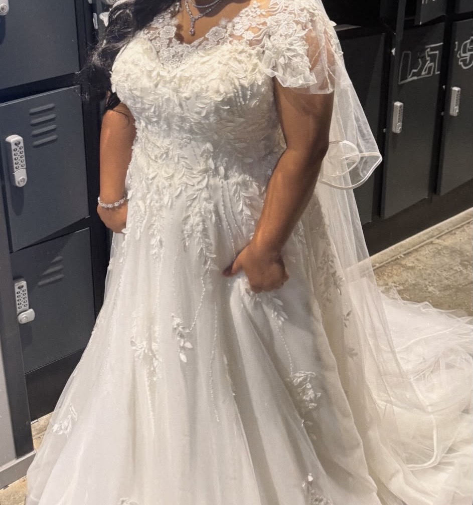 Hayes wedding dress alterations on an Essense of Australia D3529 gown with a redesigned lace neckline and illusion shoulders bride on the wedding day showing off her dress happily.