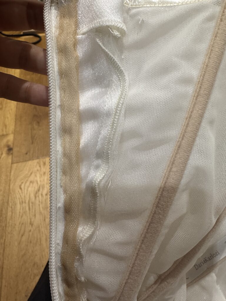 I used the extra hem fabric to add two panels on either side of zip closure then used Bardot sleeves excess to cover it under the pleats of the original bardot.
