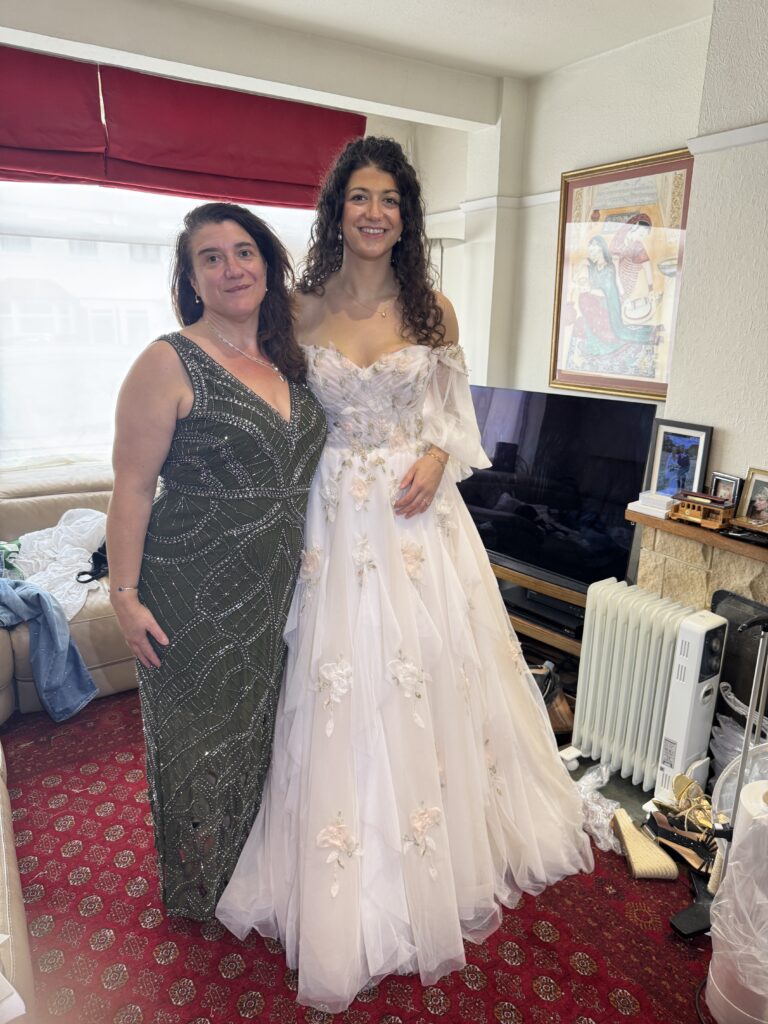 Mia in her altered Morilee bridal gown beside her mother wearing an embellished evening dress at her final fitting.