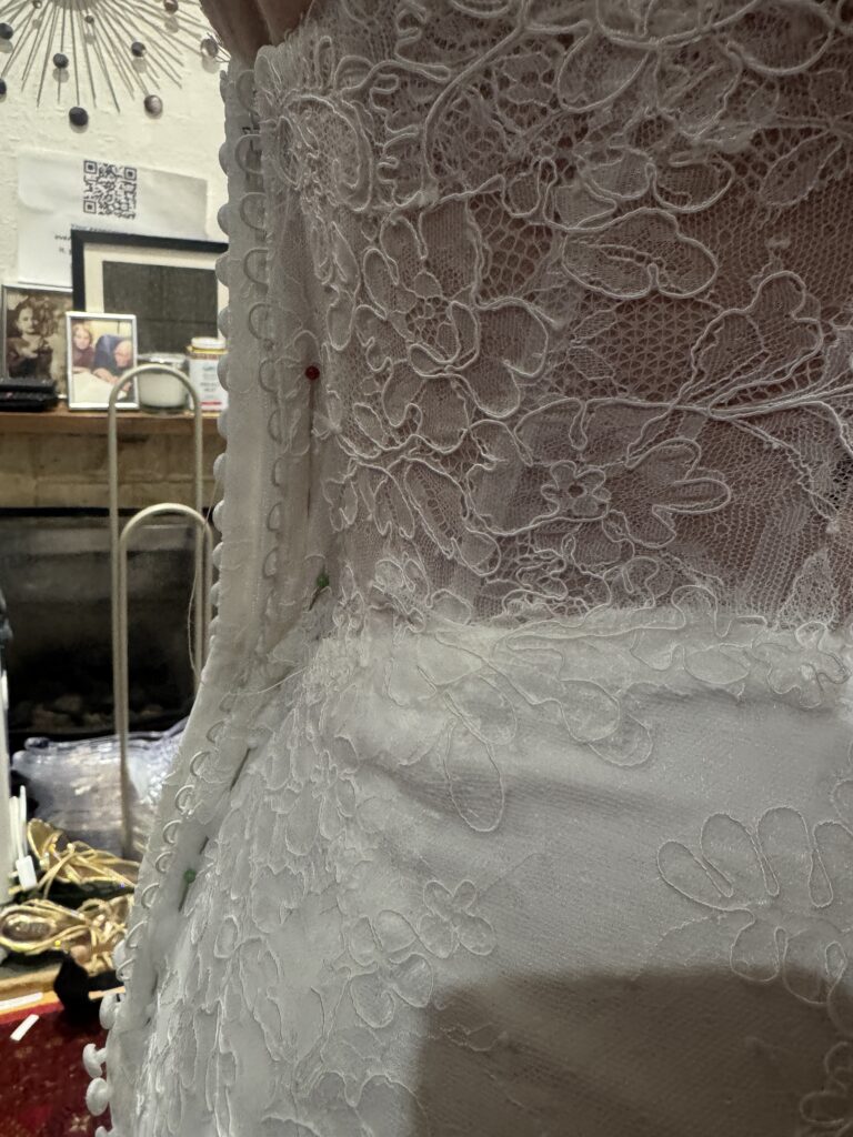 Close-up of intricate Chantilly lace and back seam adjustments on Maggie Sottero Ariadne wedding dress