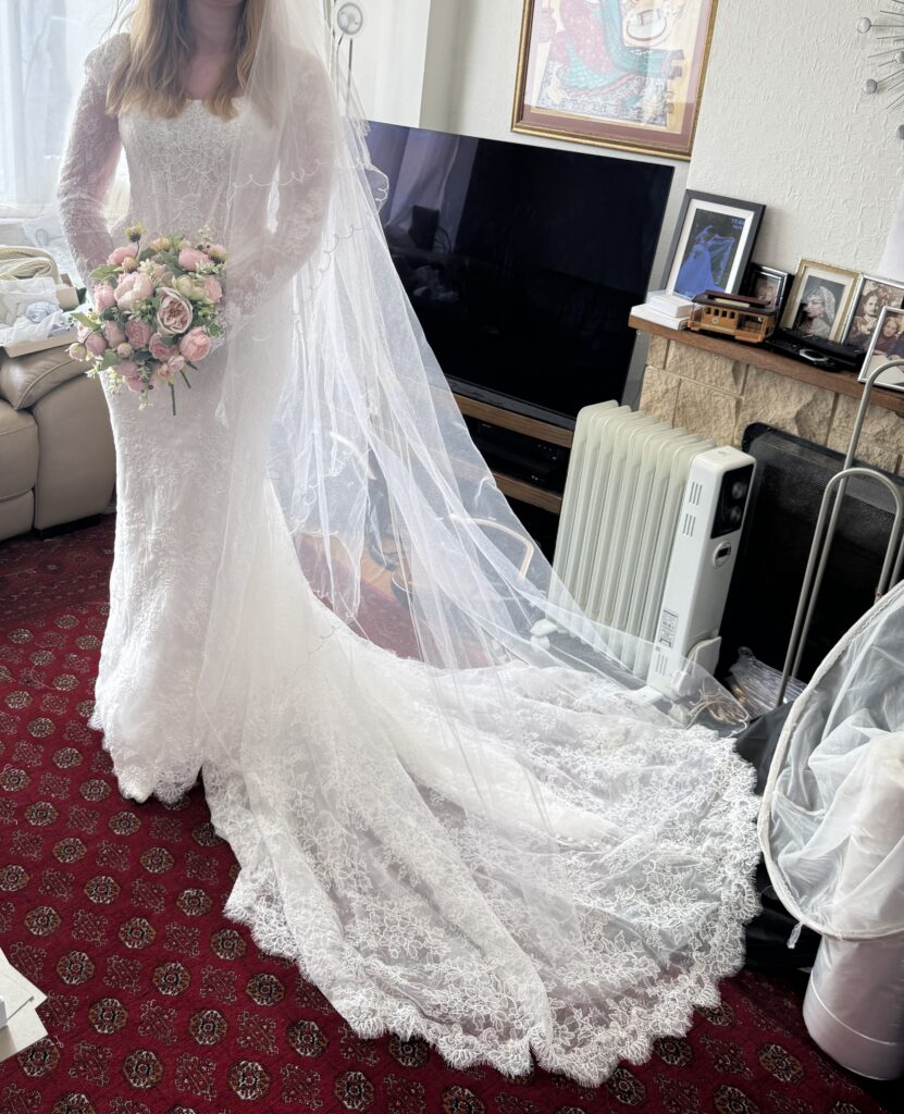 Beautifully fitted Maggie Sottero Ariadne bridal gown with long lace sleeves, veil and sweeping train