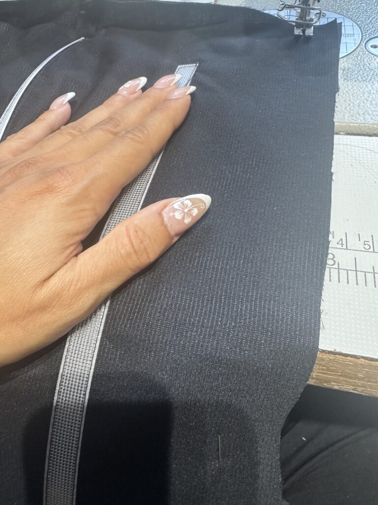 Close-up of machine stitching during construction of the black corset boning.