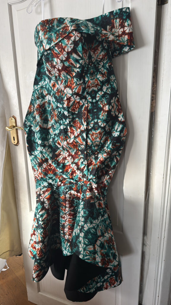 Pattern paper laid over wax-print fabric during the bespoke dressmaking process.