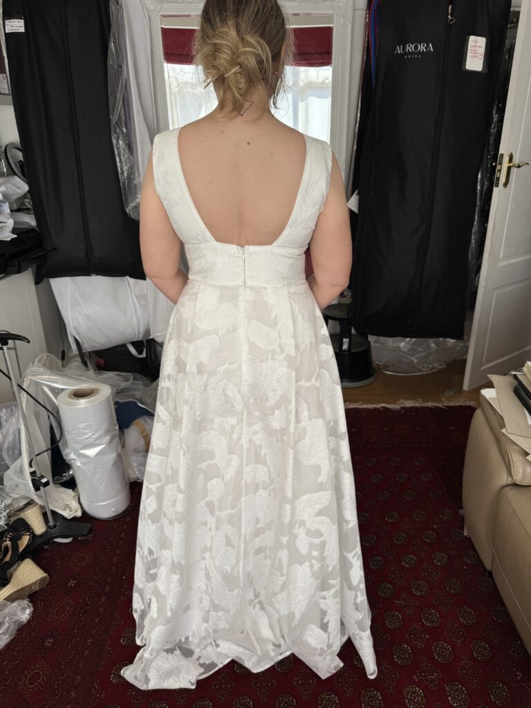 Back view of the Coast wedding dress showing its low back and fit after shoulder alterations.