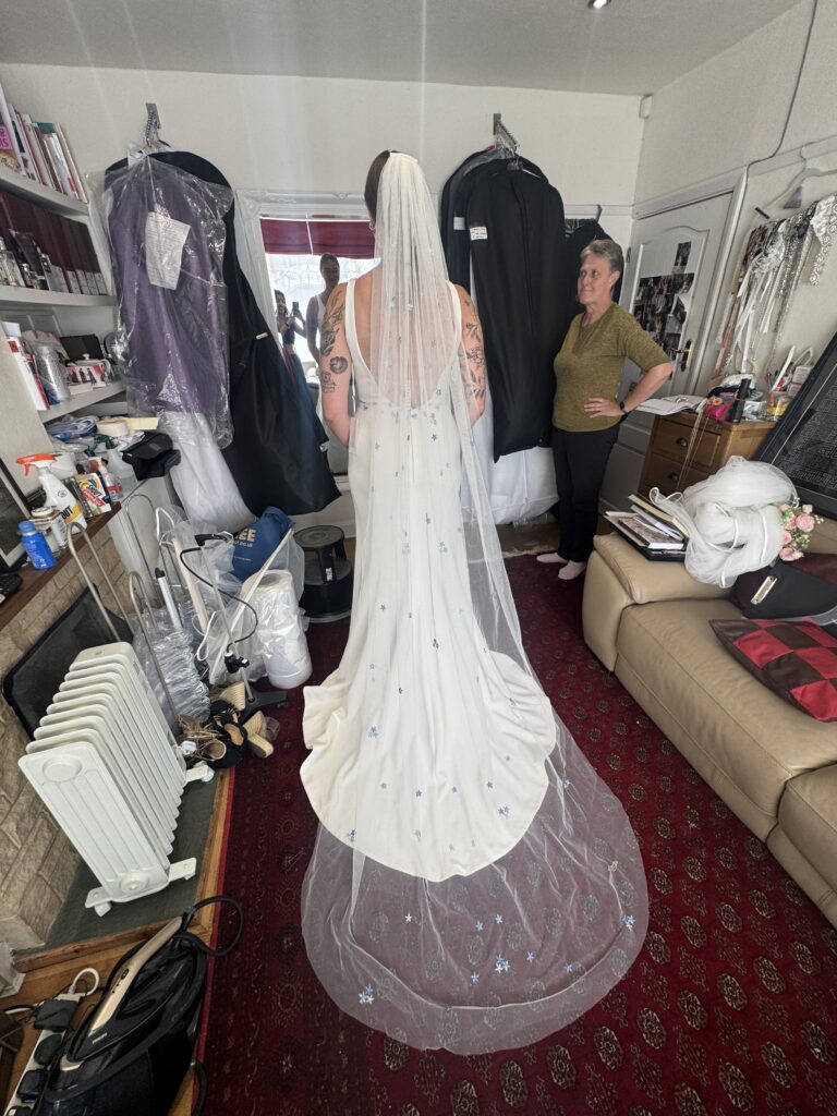 Full length Madi Lane Cooper wedding dress after bespoke bridal alterations showing back view with veil snd train.