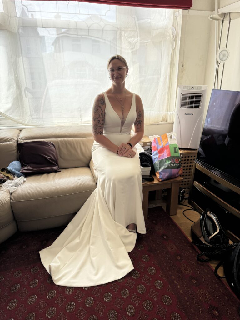 Bride seated in altered Madi Lane Cooper gown showing smooth fit and wedding dress train