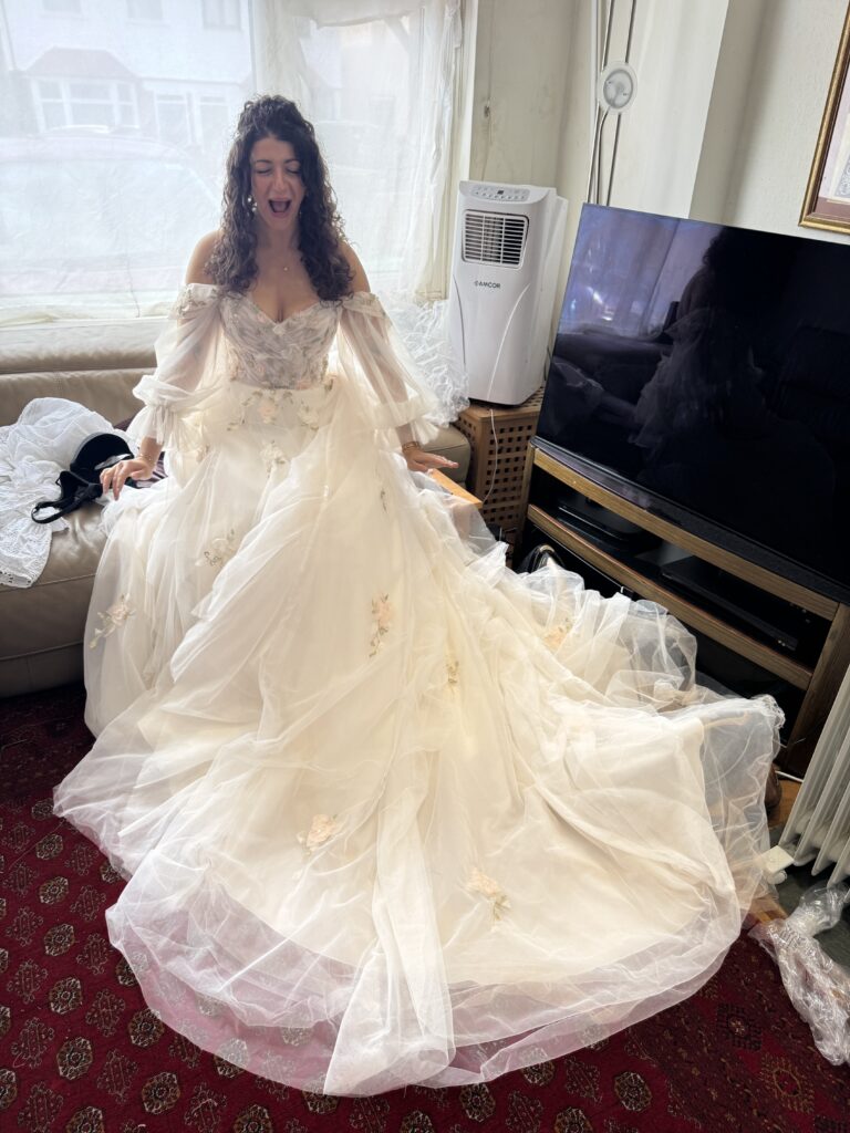 Bride seated in her altered Morilee wedding gown with romantic layers of flowing ivory tulle