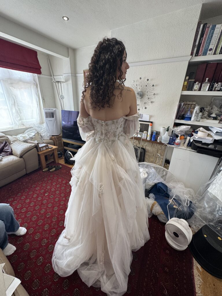 Morilee wedding dress with three bustle points lifting the layered tulle train during a bridal fitting