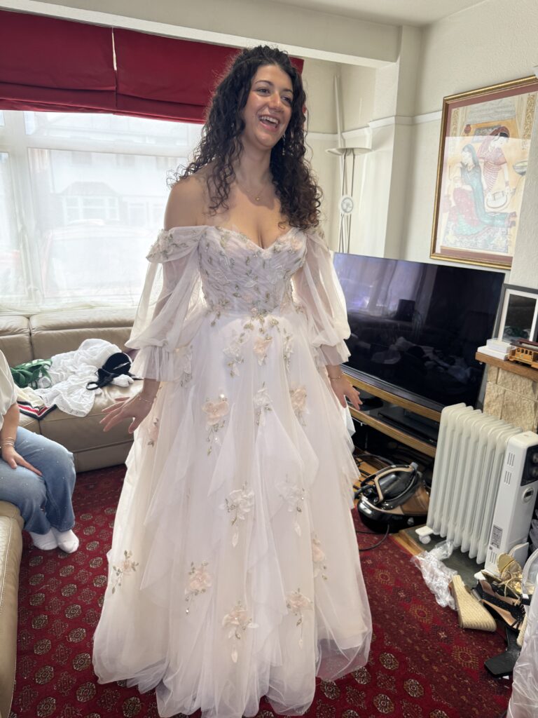 Mia smiling during her final Morilee wedding dress fitting after bodice resizing,cup reduction and additional bust support