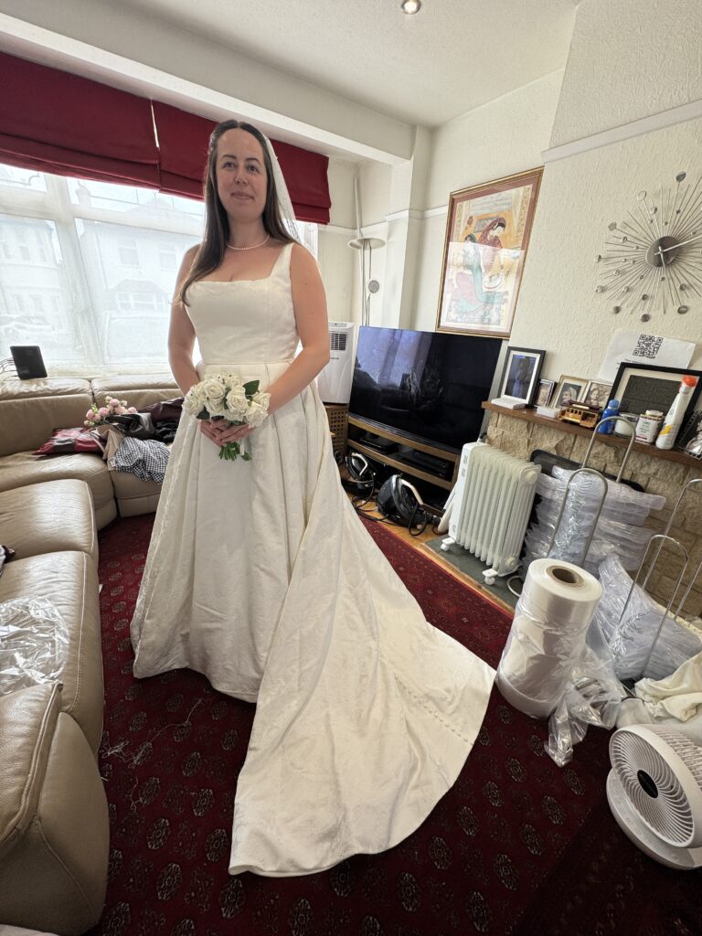 Full-length back view of Florentina bridal ballgown showing dramatic brocade train and covered buttons for Oxted Bridal alterations.