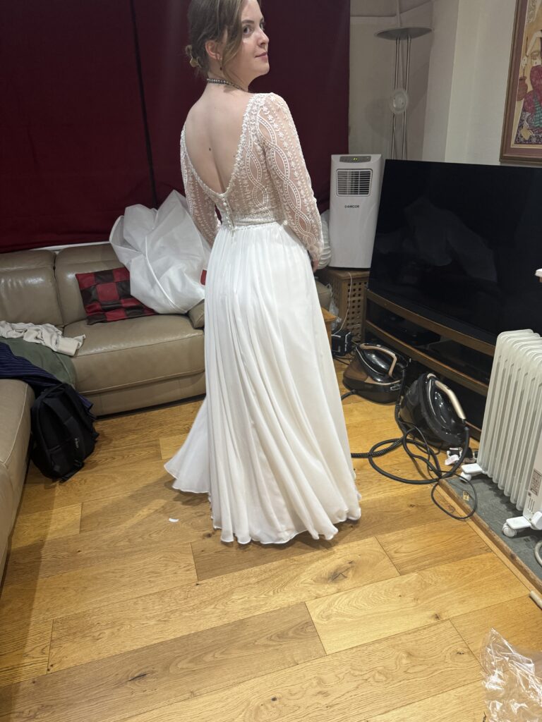 Back view of the bride’s Heidi Hudson Marisol gown showing the low back and shortened skirt after train removal